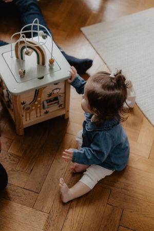 A toy bus being played with on a wooden floor from above.
