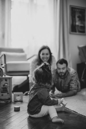 Family relaxing together on a patterned rug in a cozy living room.