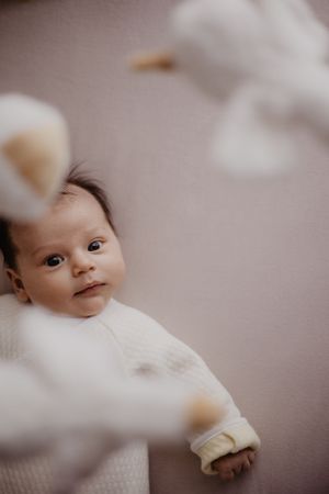 Photo d'un bébé dans son lit vue de haut lors d'une séance naissance.