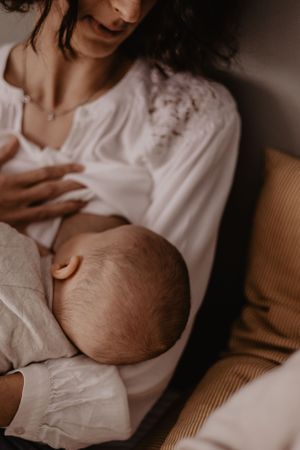 Photo d'un bébé allaitant. La mère le regarde tendrement.
