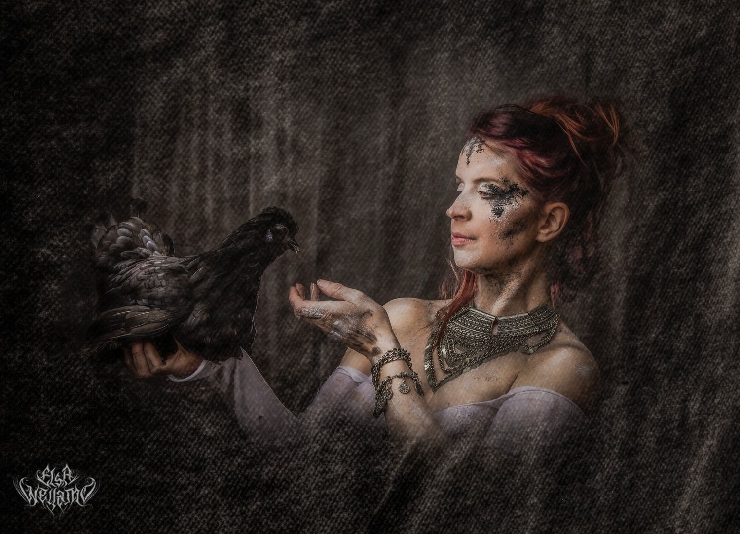 A fantasy-themed portrait featuring a woman with face paint and jewelry holding a black raven in a dark misty forest.