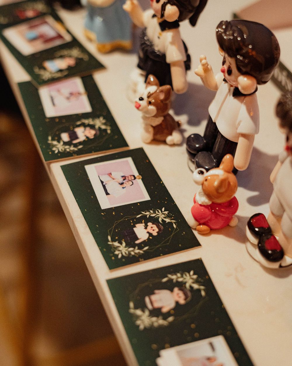 Decorative figurines displayed alongside elegant dark green photo cards.