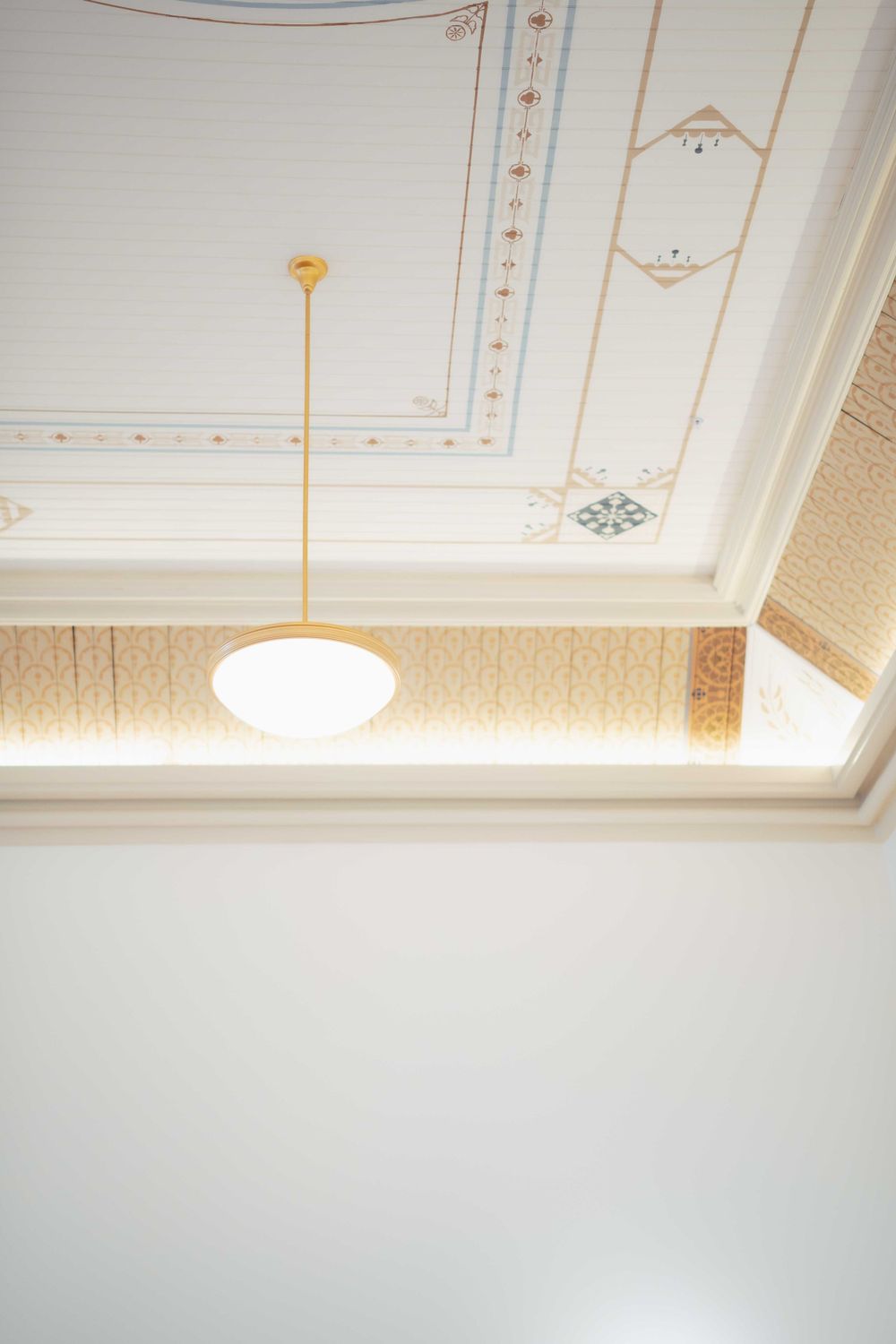 A detailed white ceiling with ornamental molding and a simple pendant light fixture. Location: Courthouse Square Woodstock, IL.