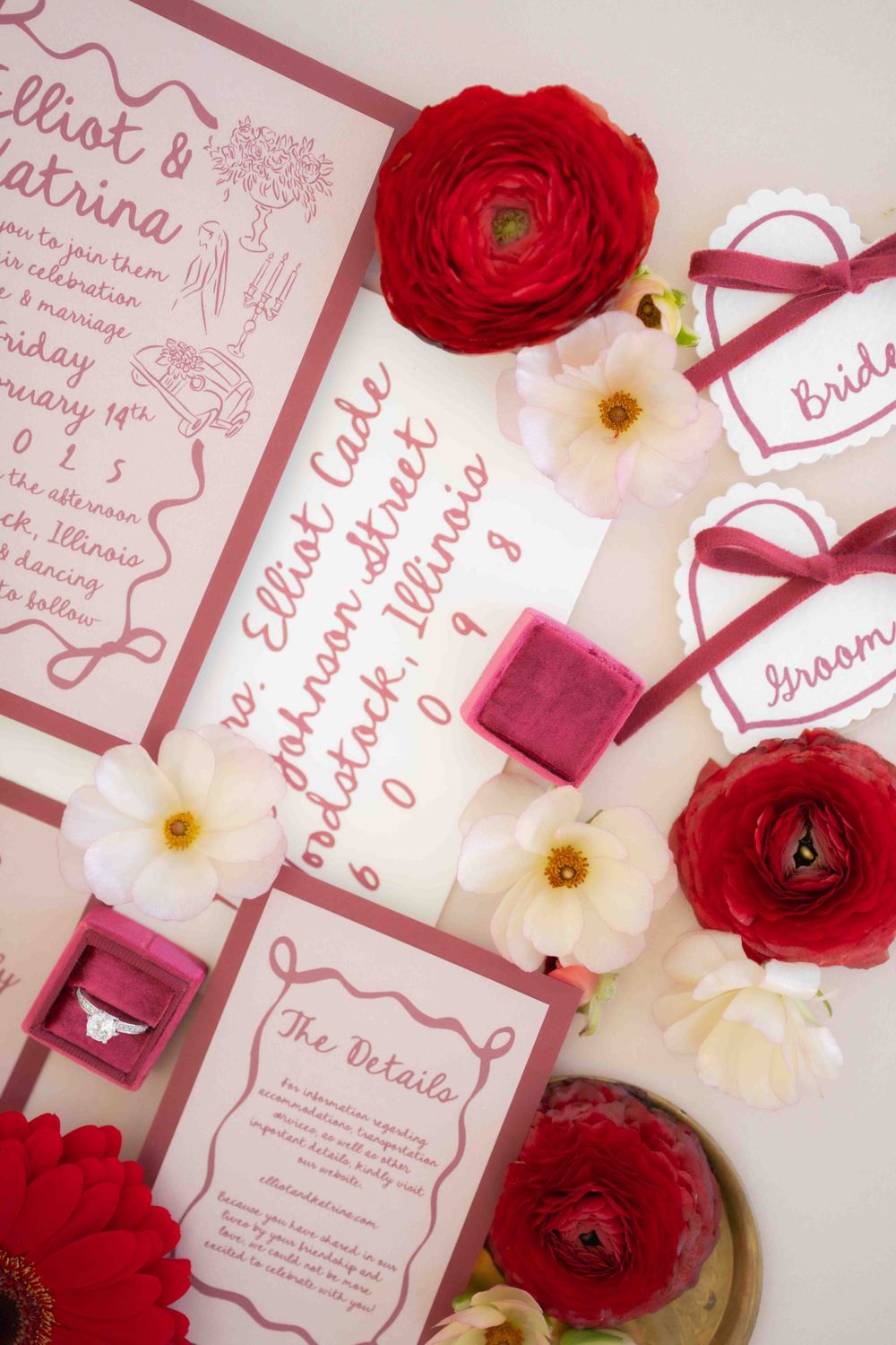 Elegant wedding invitation suite with red ranunculus flowers and white blooms against pink stationery. Events at Ethereal Courthouse Square