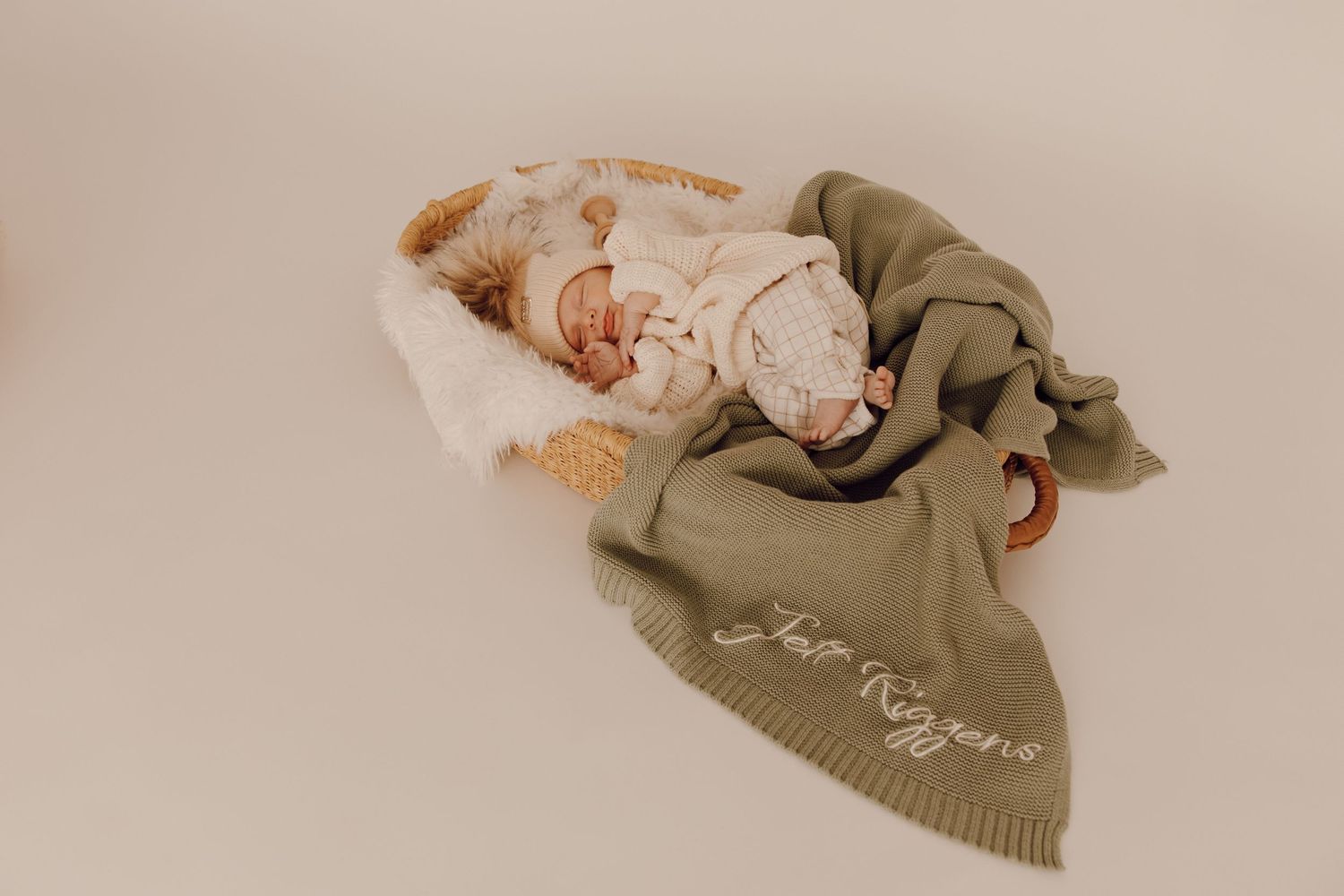 Newborn baby sleeping peacefully on a soft blanket, captured in a cozy indoor photoshoot