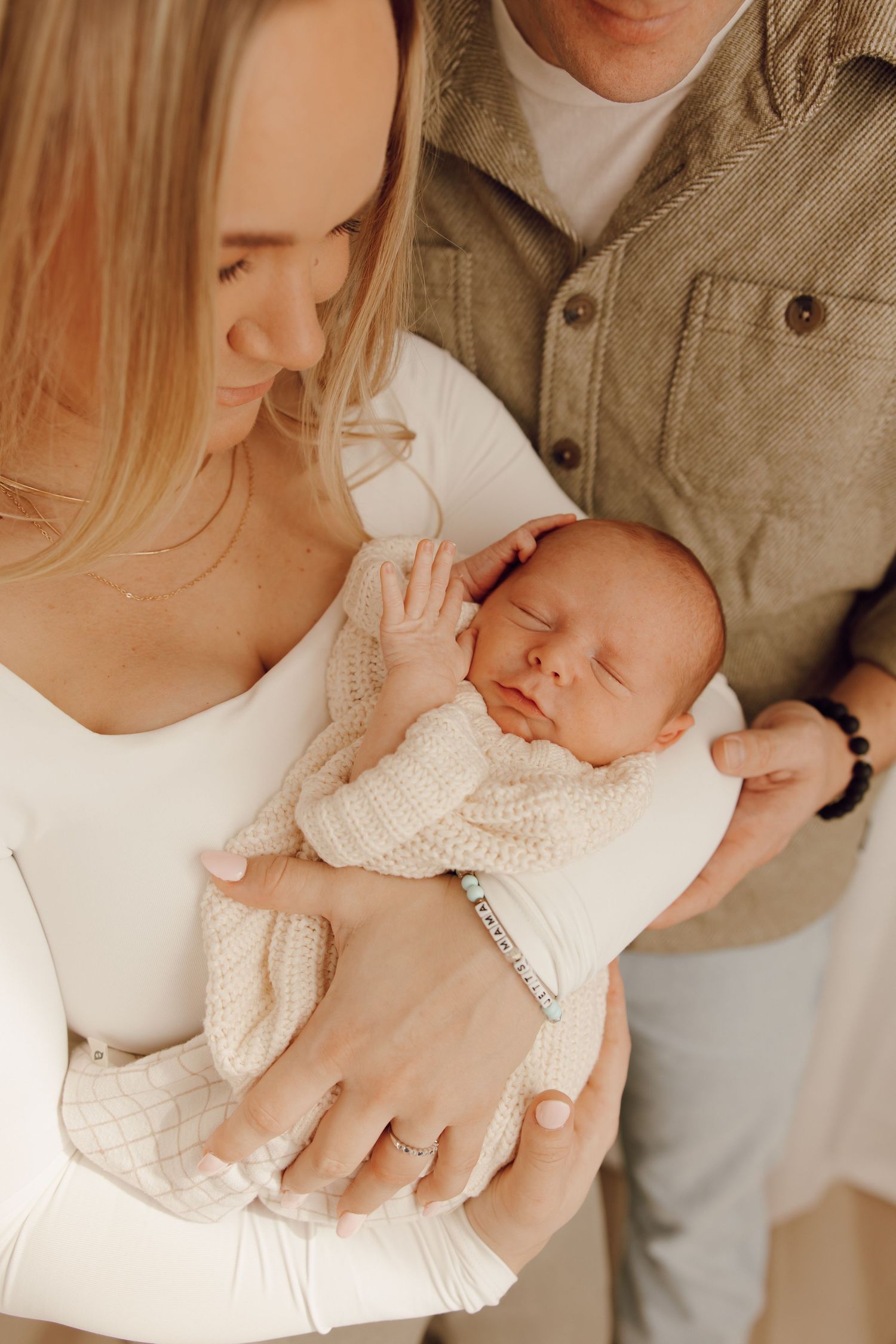 Adorable newborn portrait of a baby with closed eyes, peacefully cradled in a photographer's hands.