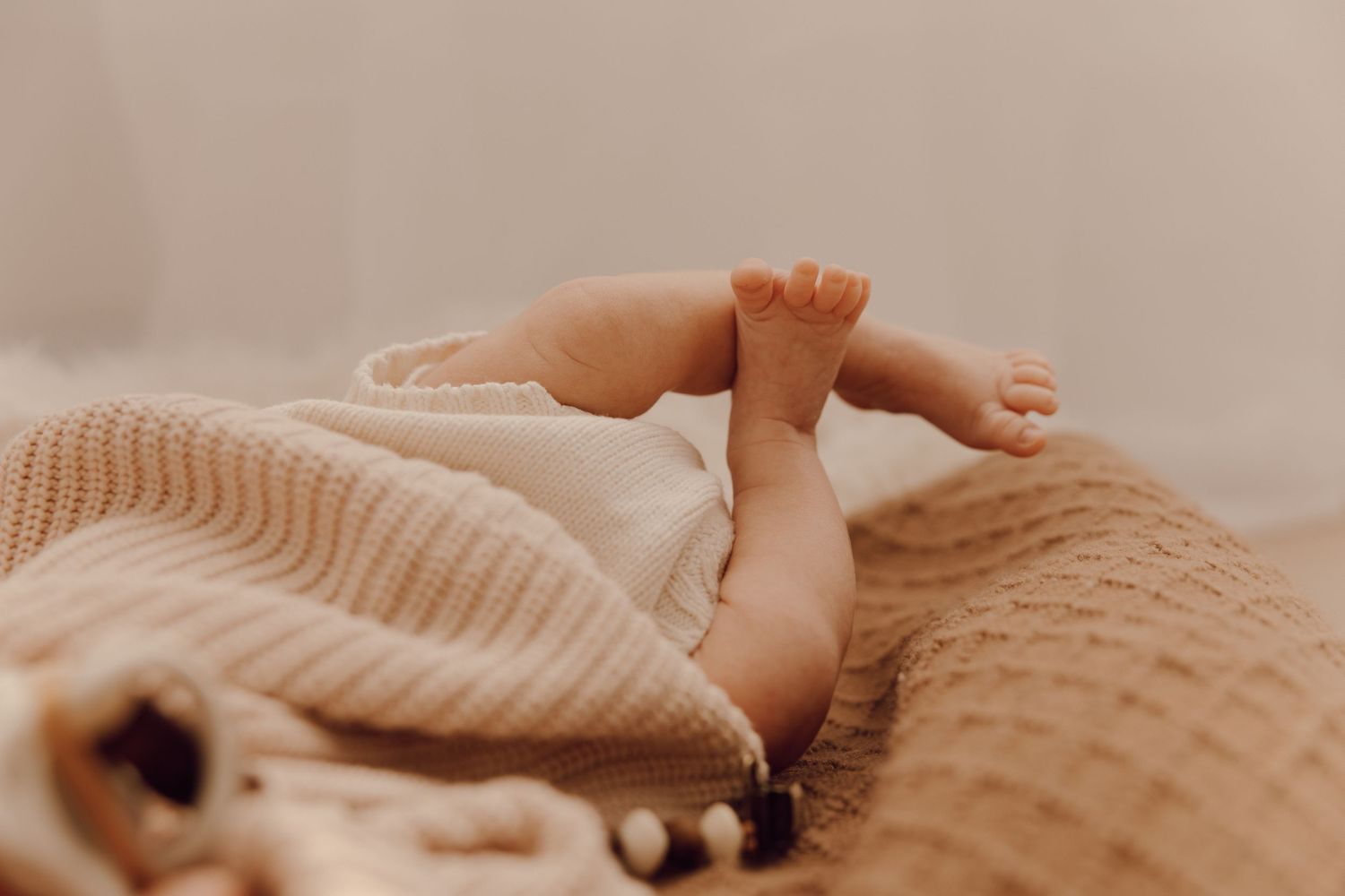 Newborn baby sleeping peacefully on a soft blanket, captured in a cozy indoor photoshoot.