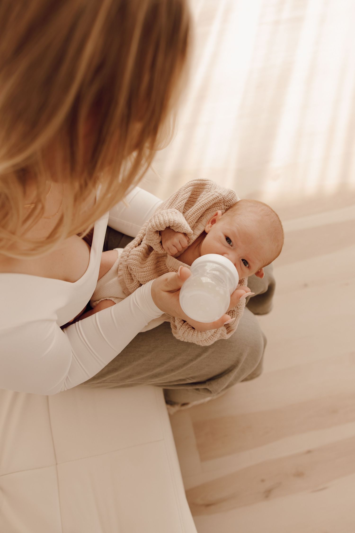 Adorable newborn portrait of a baby with closed eyes, peacefully cradled in a photographer's hands.