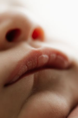 Close-up macro photograph of soft lips and skin with shallow depth of field creating a dreamy effect.