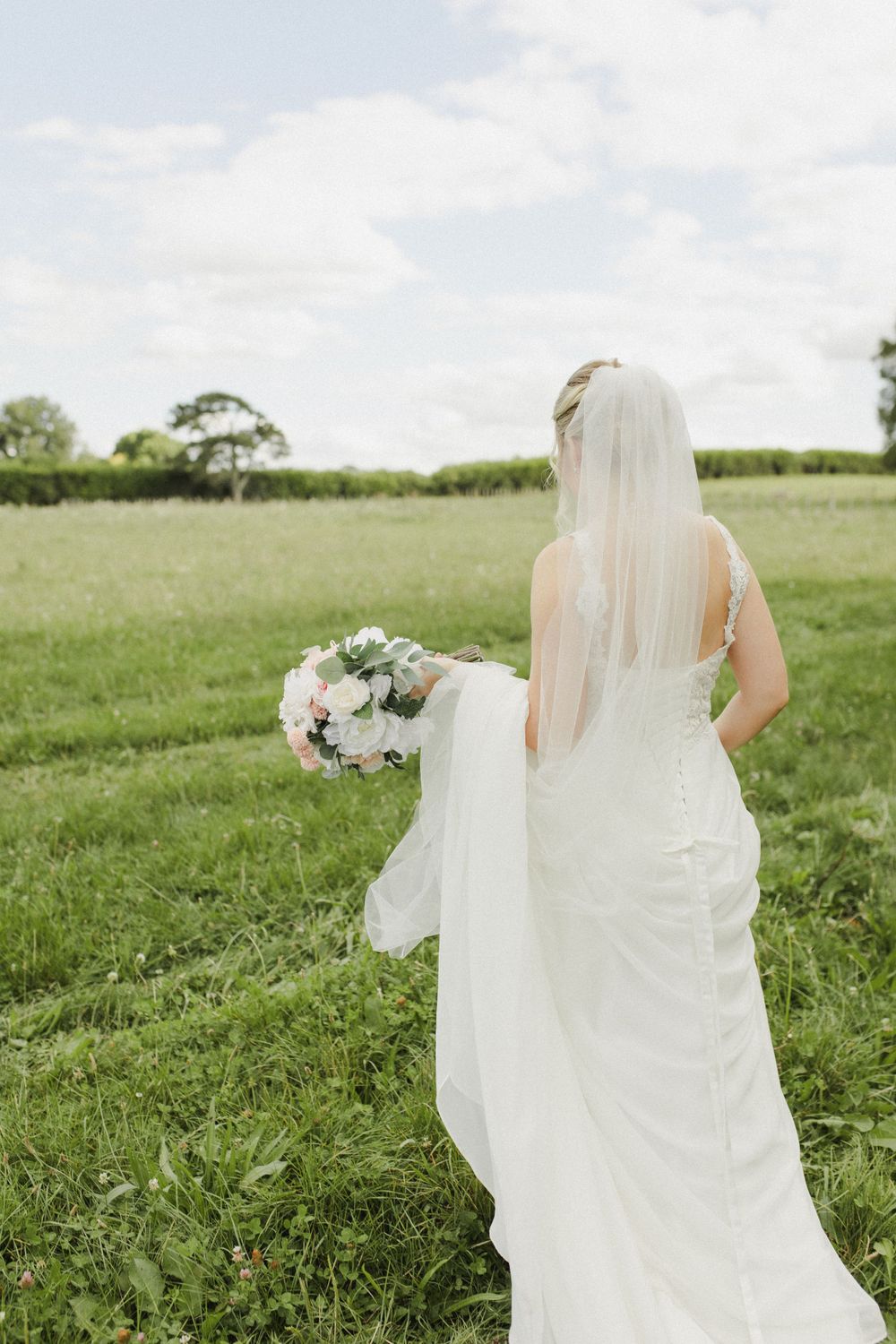 Bride walking along field Rosenvale venue wedding