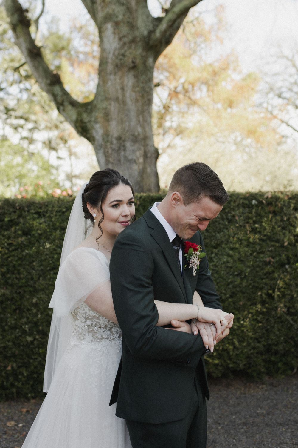 Bride hugging groom from behind at Woodlands Estate