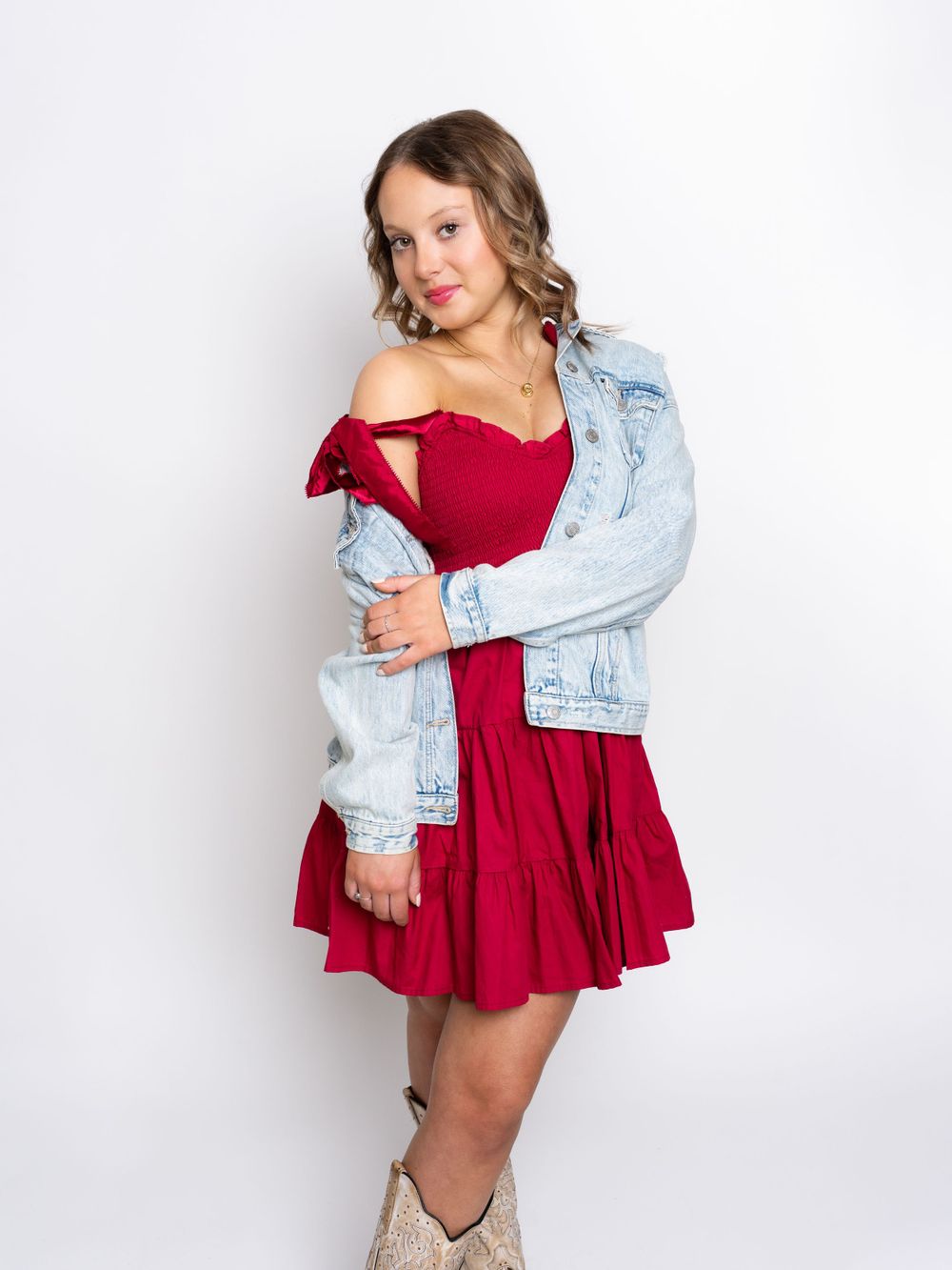 Photo of senior girl in red dress and jeans jacket photographed by senior portrait photographer in Jefferson County TN