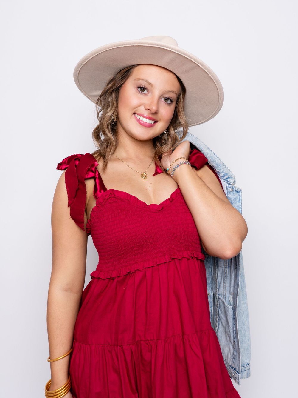 Photo of high school senior girl in red dress and wide brimmed fedora hat by senior photographer in Dandridge, TN