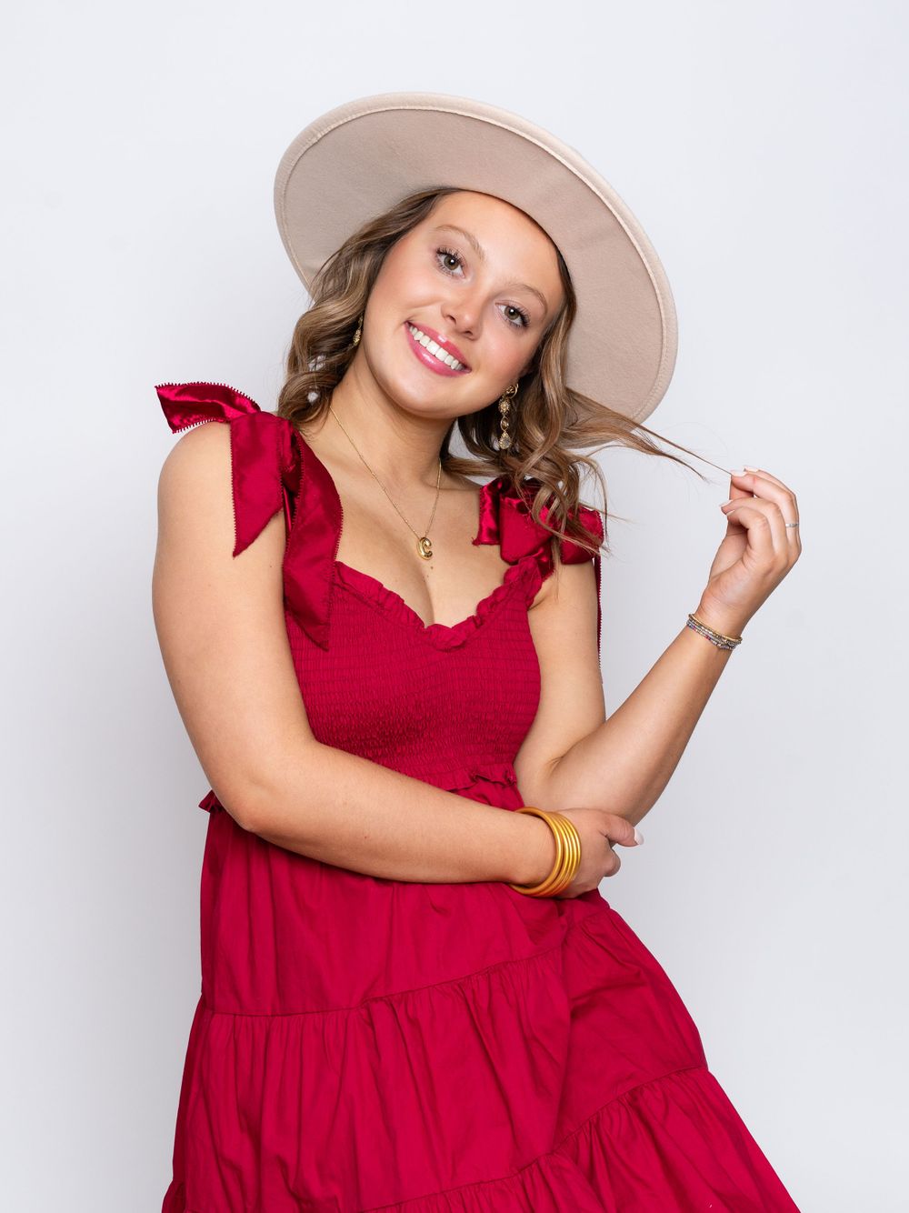 Photo of high school senior girl in red dress and wide brimmed fedora hat by senior photographer in Dandridge, TN
