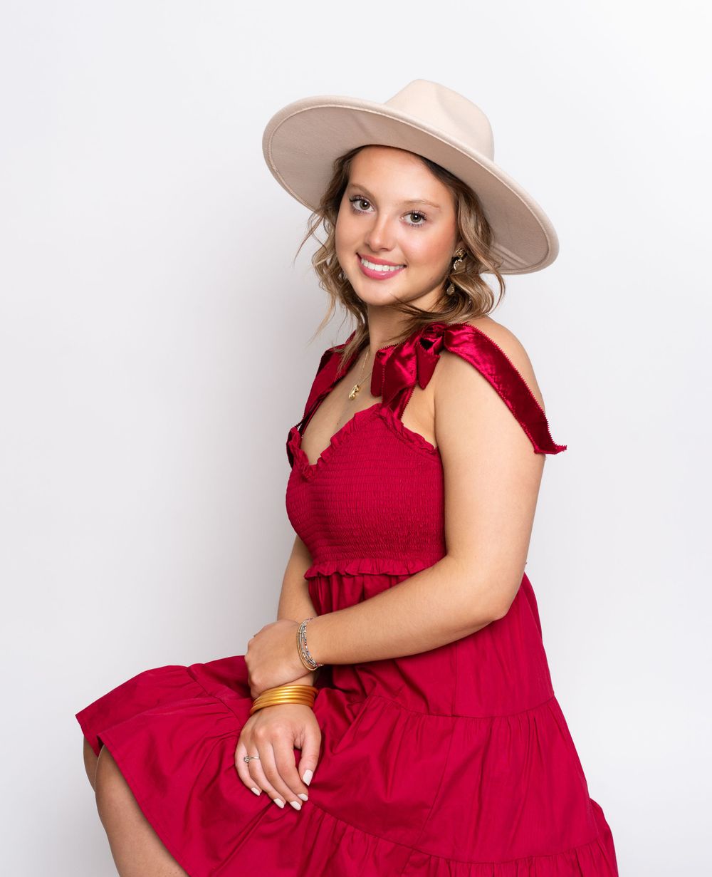 Photo of high school senior girl in red dress and wide brimmed fedora hat by senior photographer in Dandridge, TN