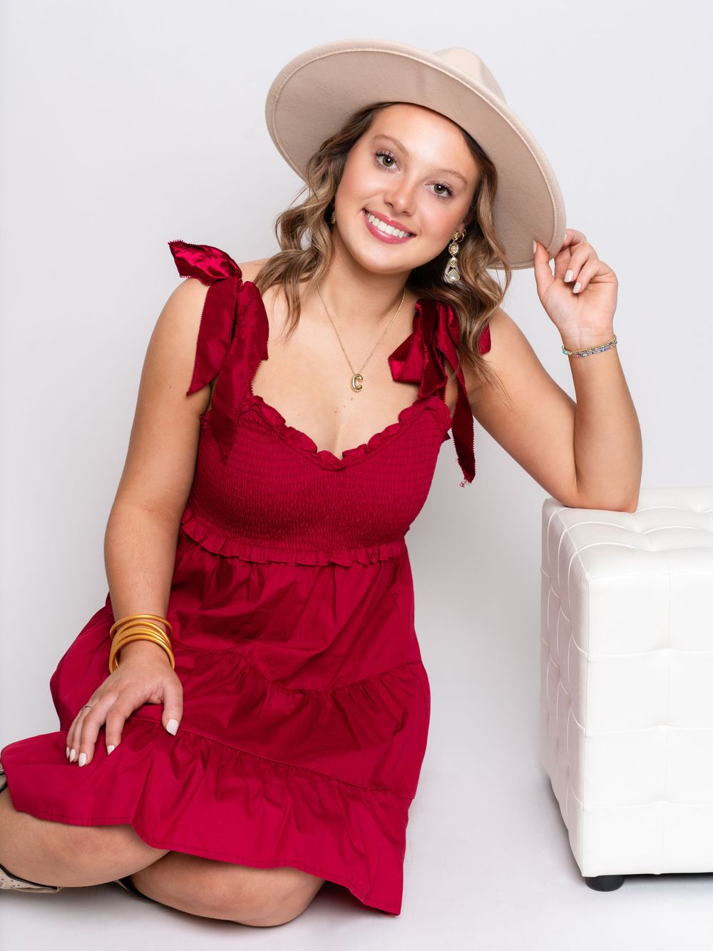Photo of high school senior girl in red dress and wide brimmed fedora hat by senior photographer in Dandridge, TN