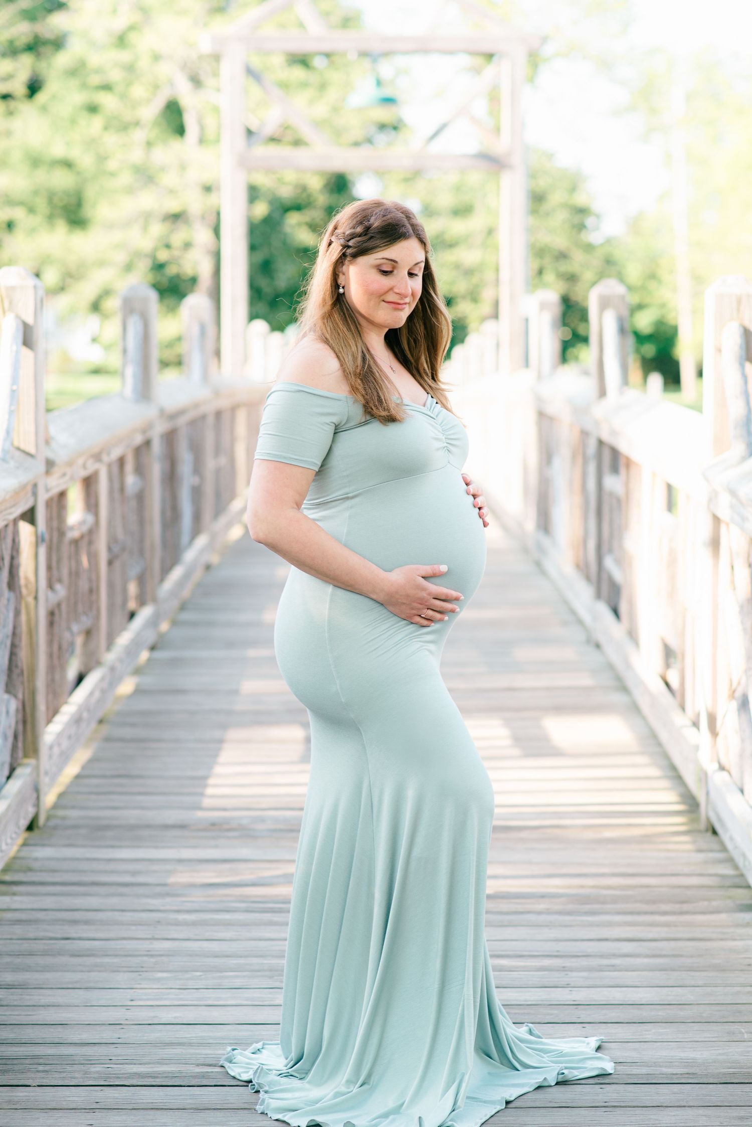 A maternity photo shoot of a woman on a bridge in spring lake nj.