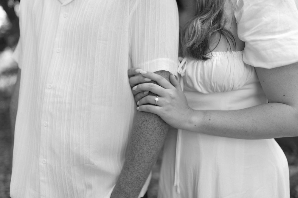 Black and white detail shot of a couple's tender embrace.