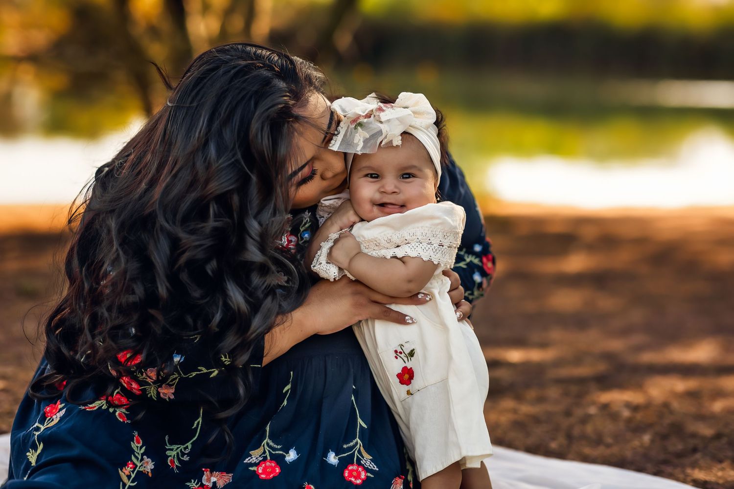 Tender moment between mother and child outdoors during golden hour near a lake in Chandler for their photo session