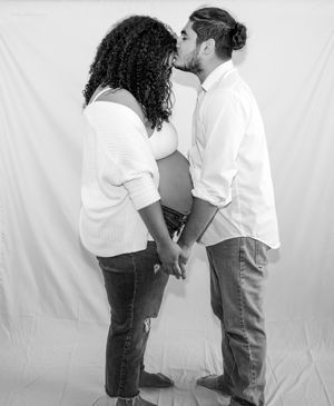Black and white photo of couple sharing tender moment during maternity shoot.