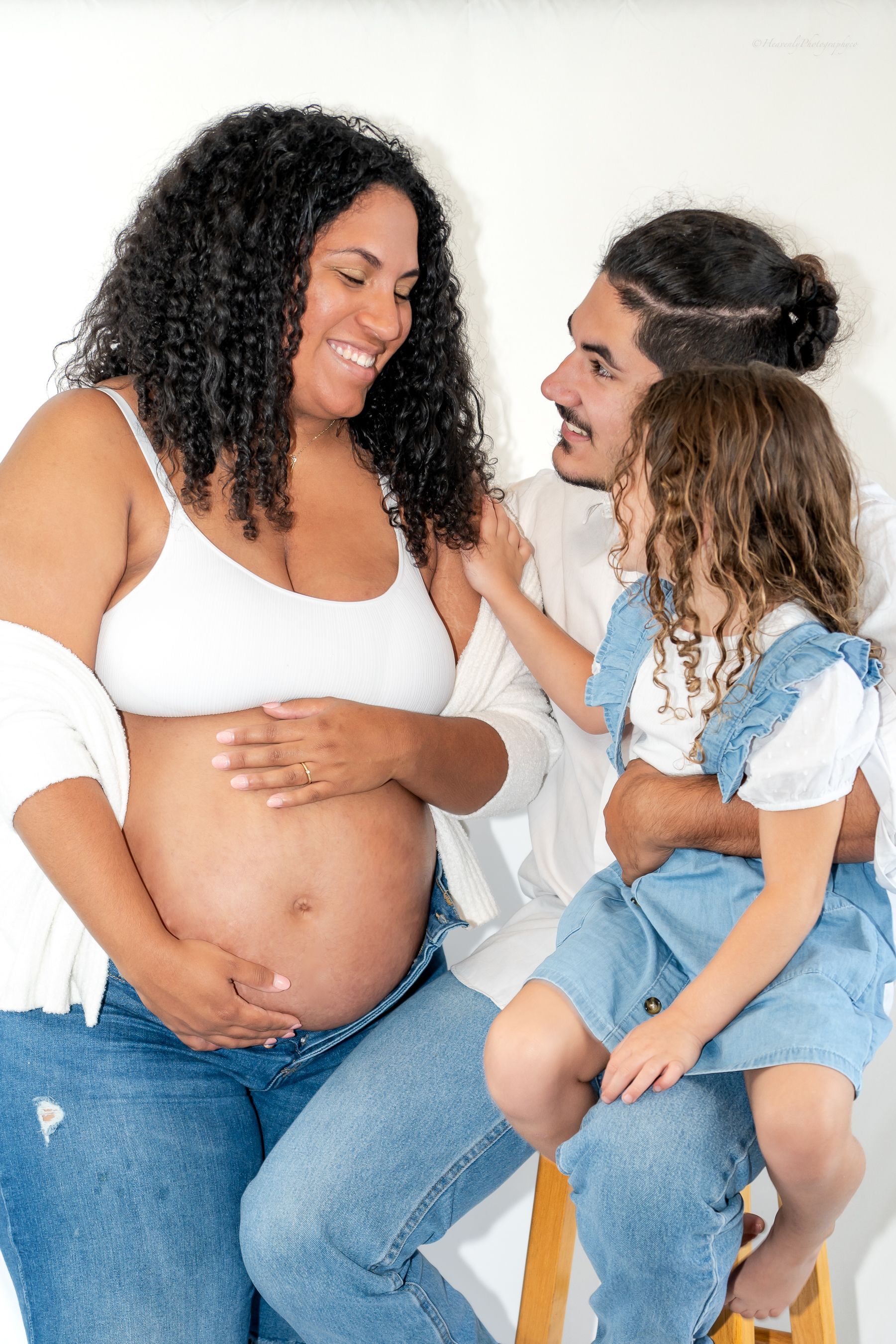 Candid maternity photo of family sharing happy moment together.