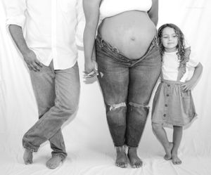 Black and white family maternity photo with young child and parents.
