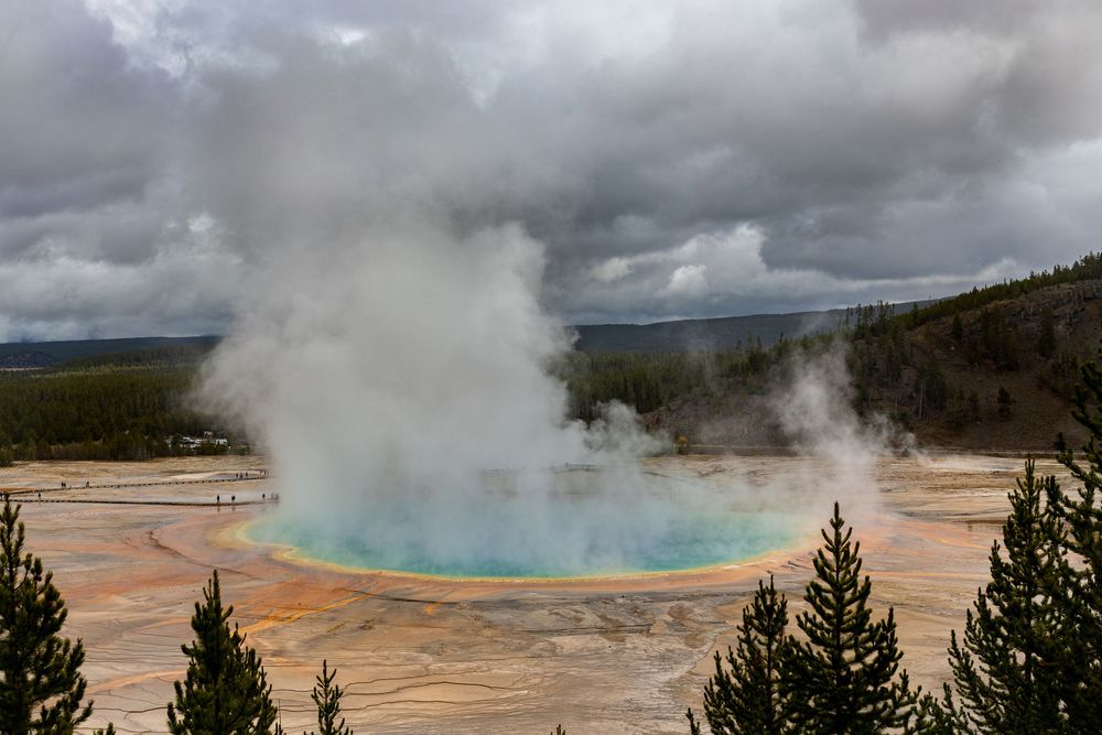 La majestuosa Grand Prismatic Spring entra en erupción con actividad geotérmica humeante contra un espectacular cielo nublado en yellowstone