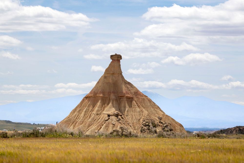 Una majestuosa formación rocosa del desierto se alza imponente contra un vibrante cielo azul, simbolizando la belleza natural y los paisajes