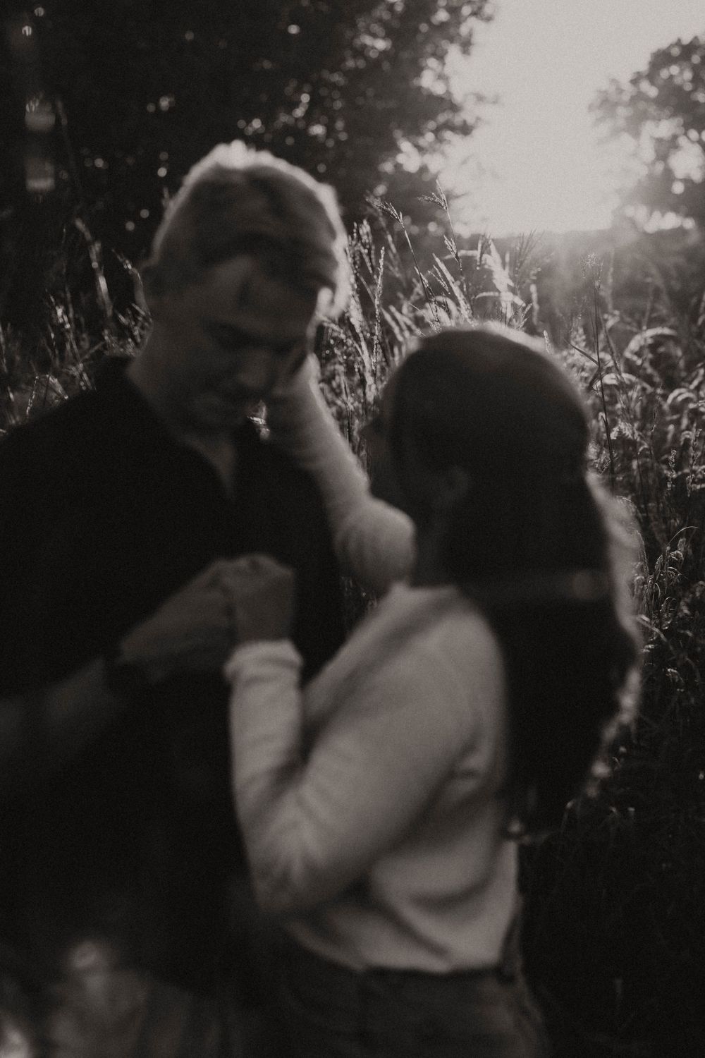 A tender black and white moment captured in a natural outdoor setting.