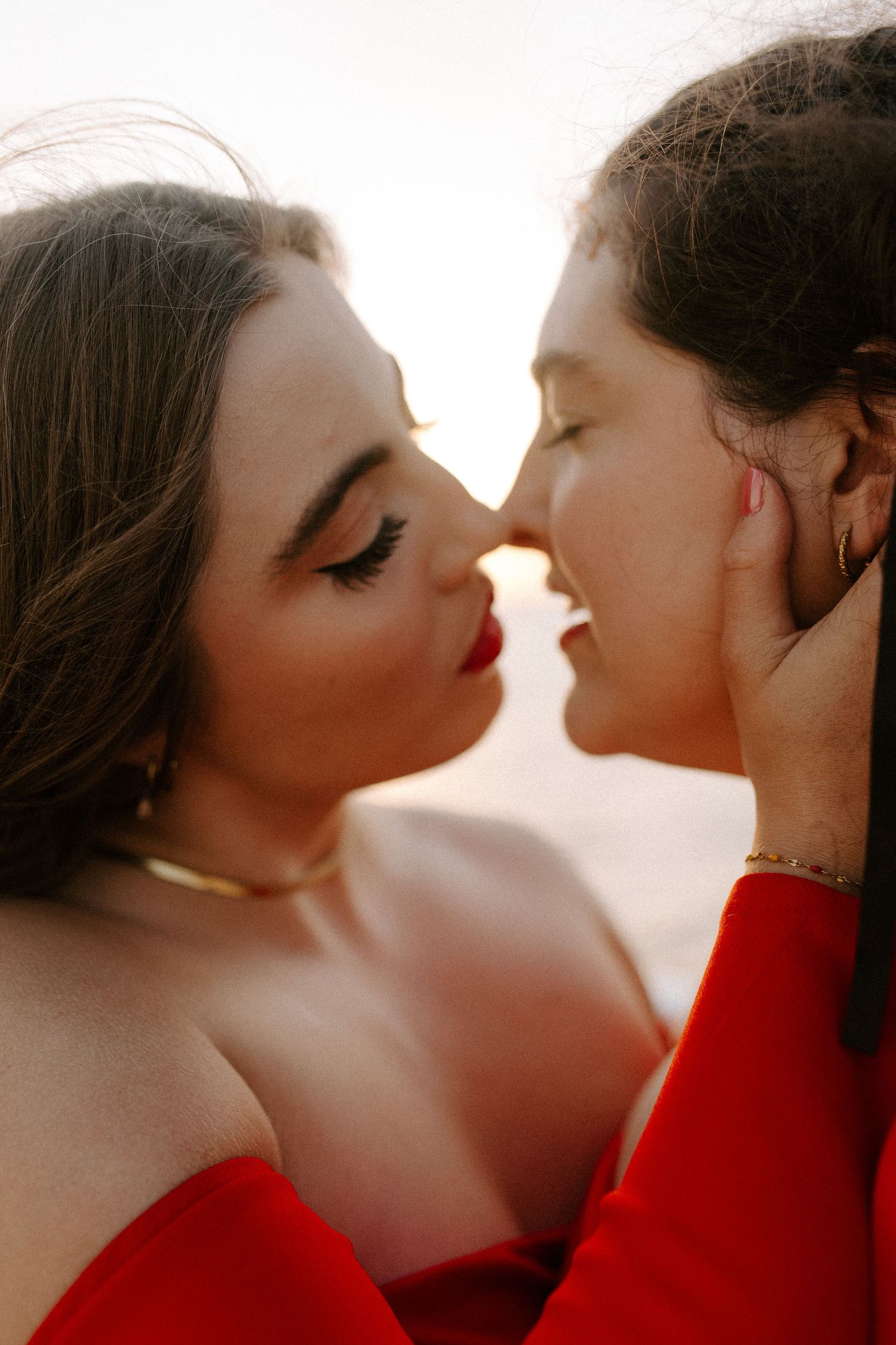 A romantic close-up photograph of two people in red attire about to kiss.