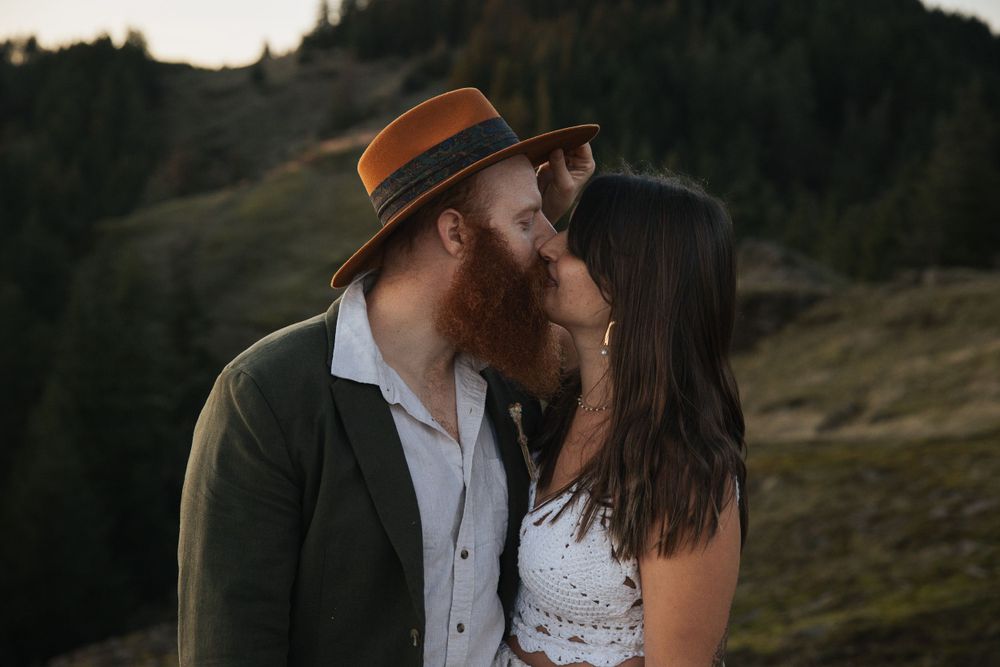 Intimate close-up of couple in vintage wedding attire during mountain sunset photoshoot.