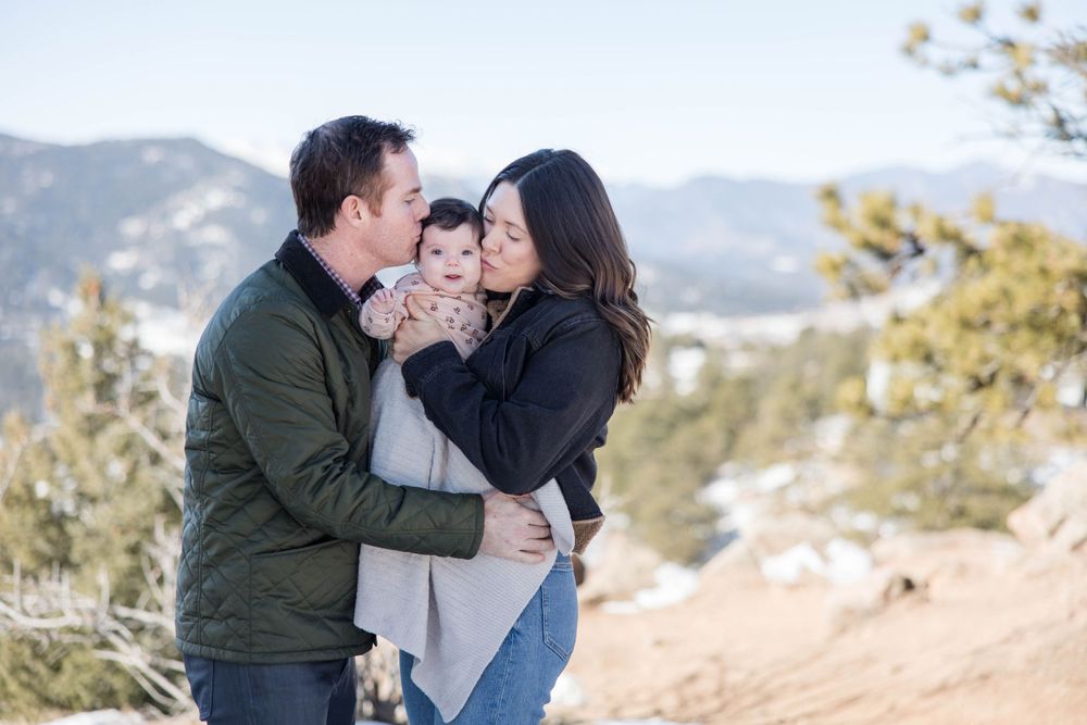 Intimate family moment captured against mountain backdrop.