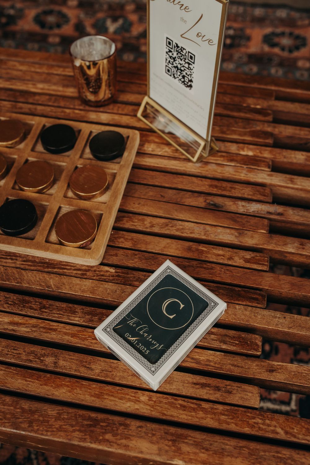 Set of playing cards and QR code menu on wooden table with small metallic cup and wooden tray of makeup.
