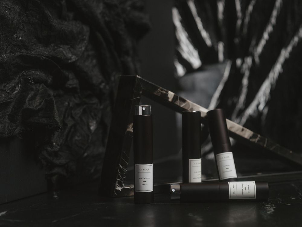 Black and white still life photograph of wine bottles arranged on dark surface with dramatic lighting and shadows.