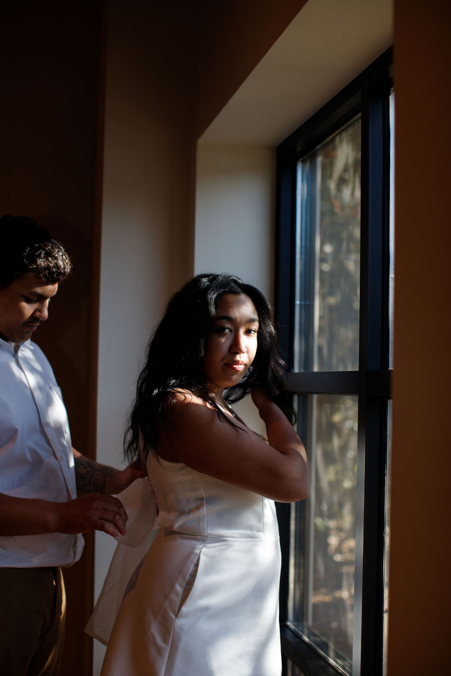 groom helping bride with dress wedding pose
