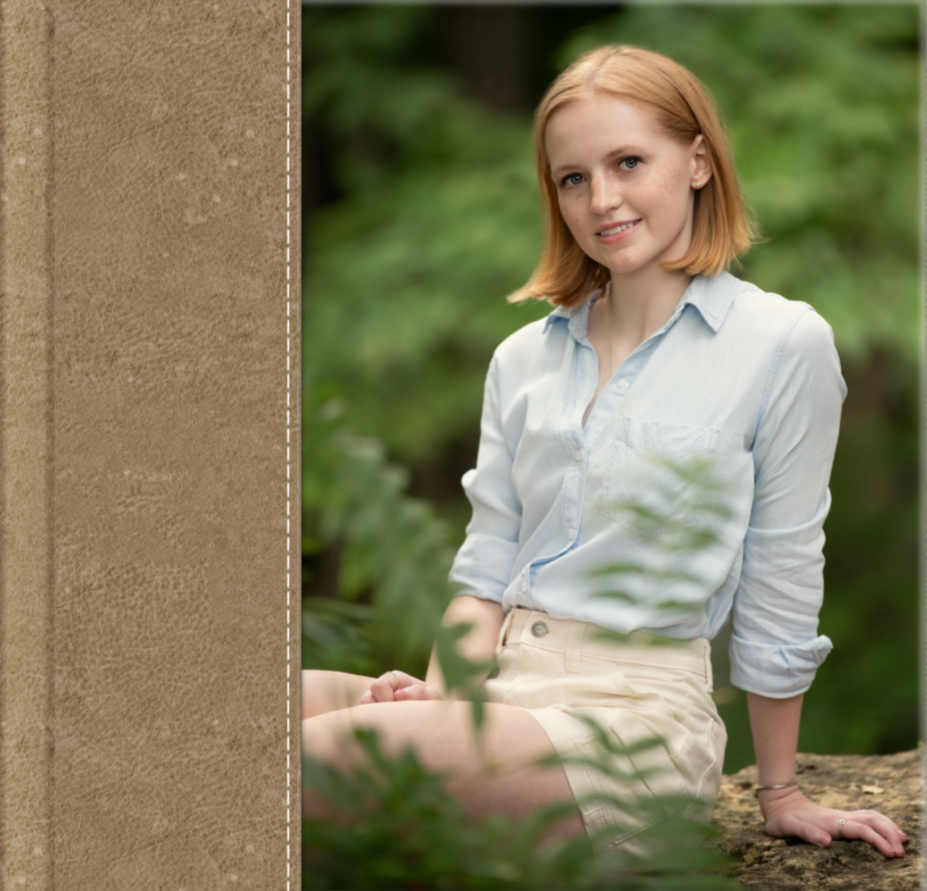 Figure in light blue button-up shirt and khaki shorts poses outdoors against blurred green foliage background.