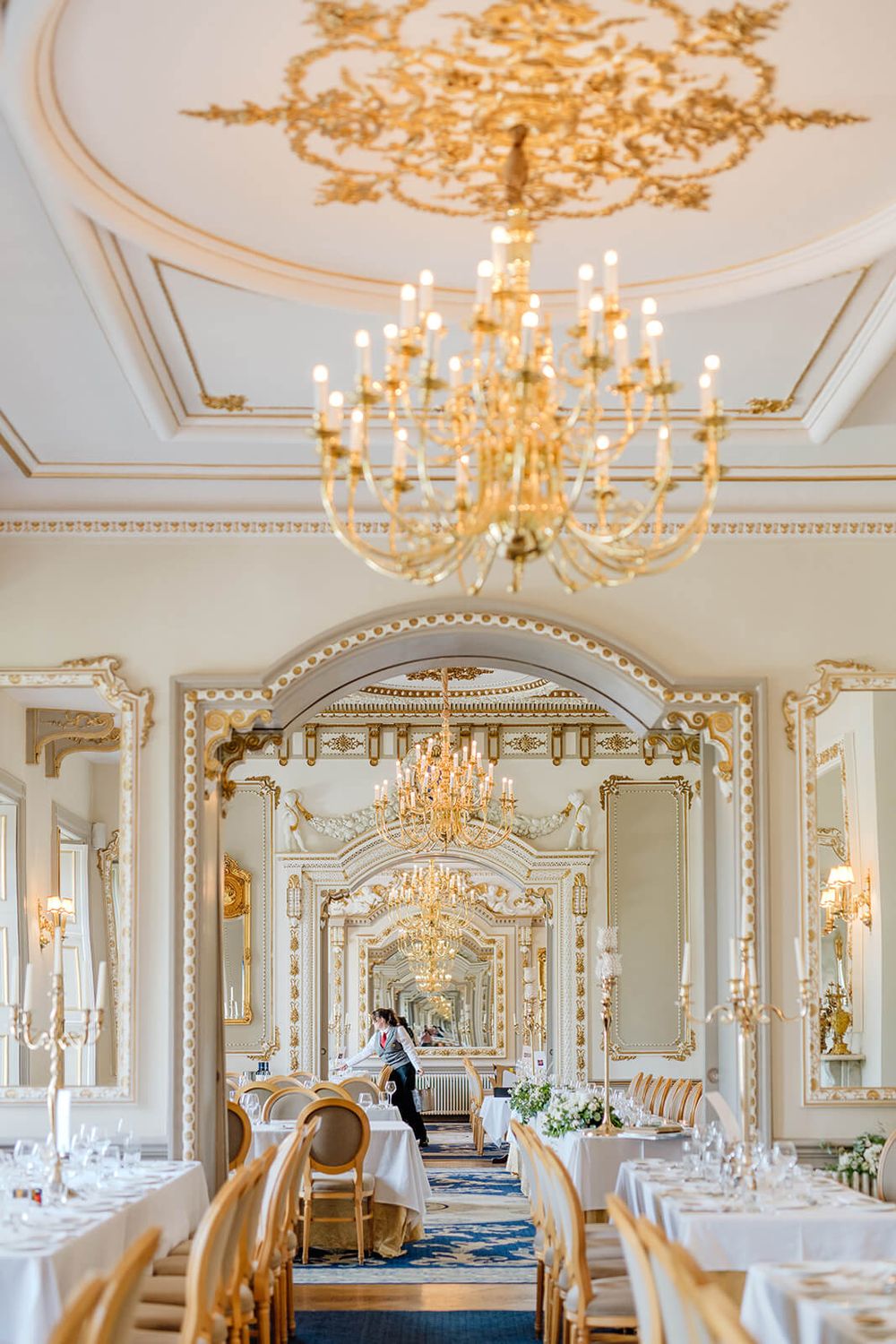 Ornate ballroom with crystal chandeliers and elegant table settings for wedding reception in Markree castle, Ireland.