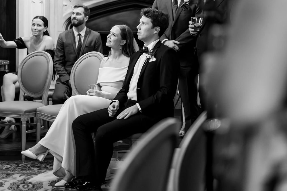 Wedding guests seated in ornate chairs share joyful laughter during a wedding speeches at Sligo wedding reception.