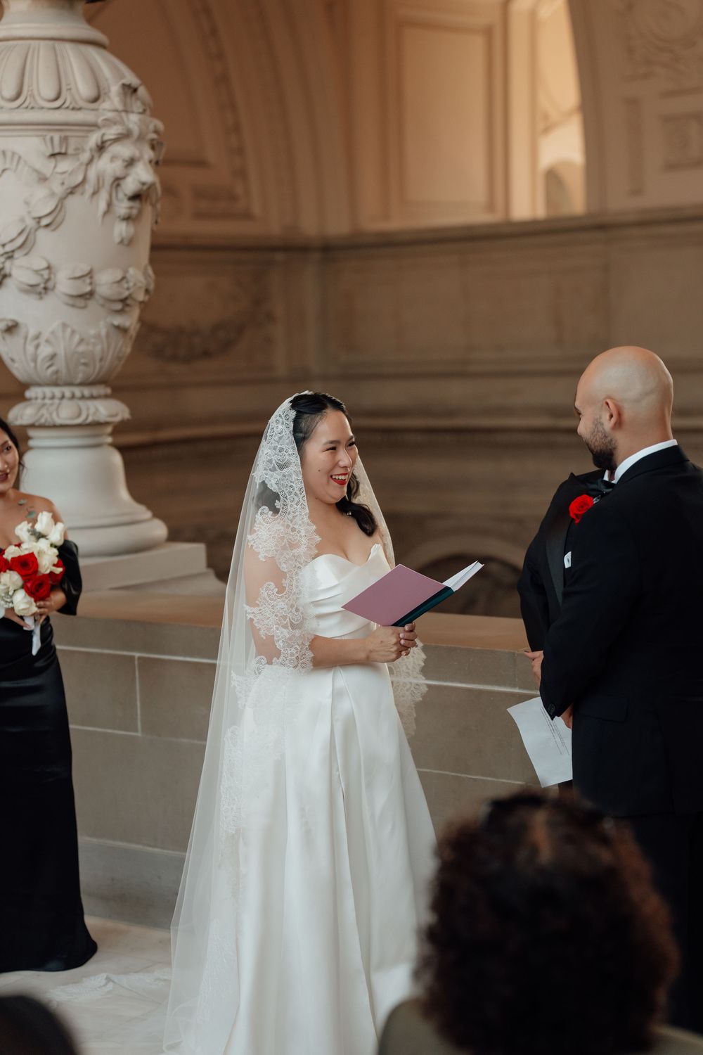Wedding ceremony moments captured in an ornate hall with classical architectural details.