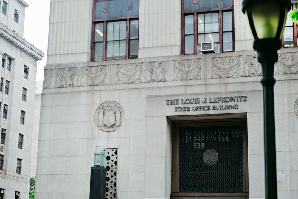 Ornate architectural details and lamp posts adorn the entrance of a historic New York City apartment building.