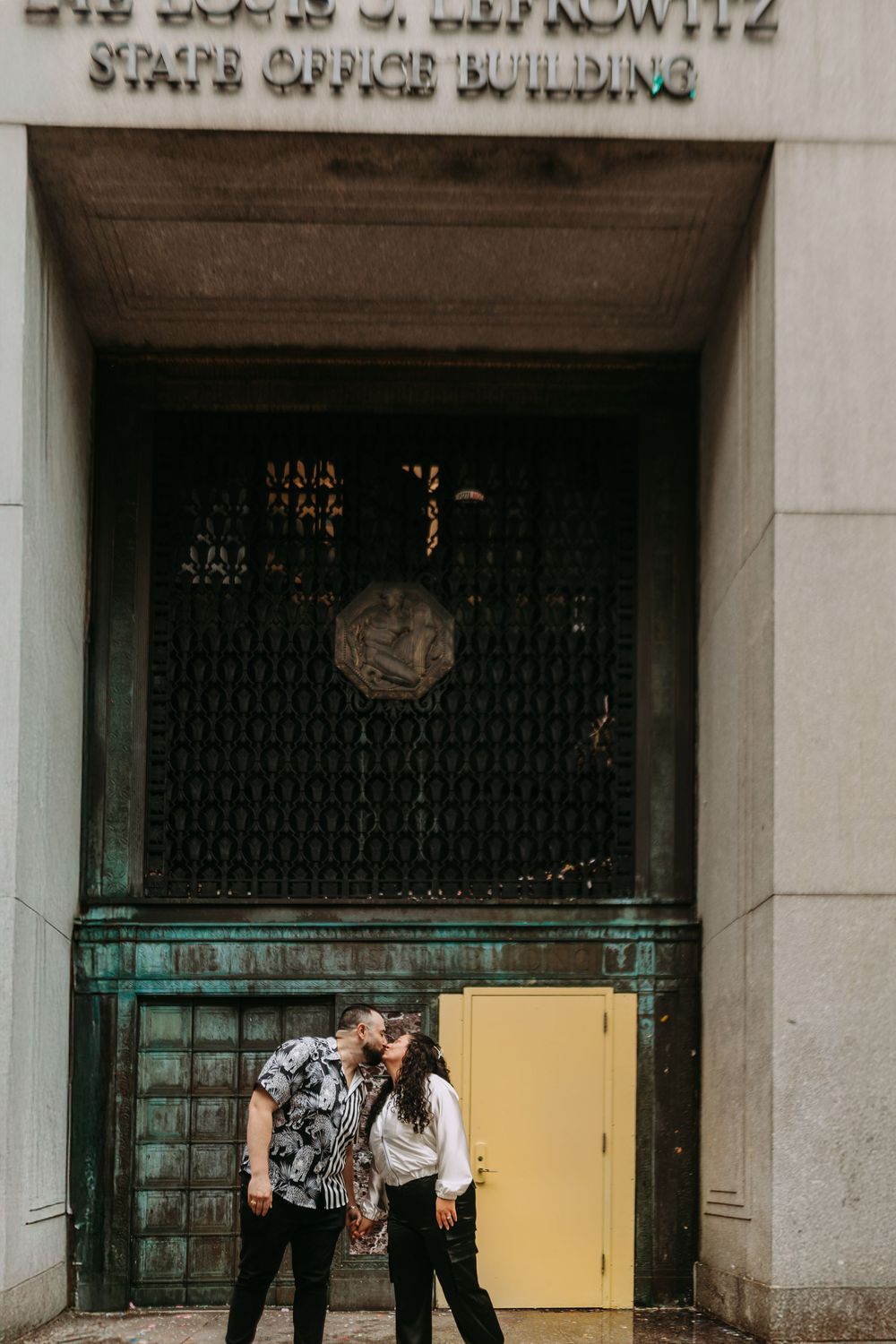 Storefront of vintage building with ornate architectural details and metal grating on windows.