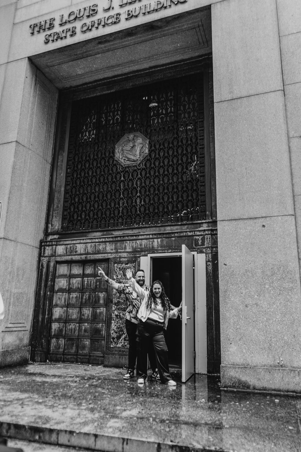A series of four black and white photos showing protesters outside the Louis J. Horowitz Building entrance.