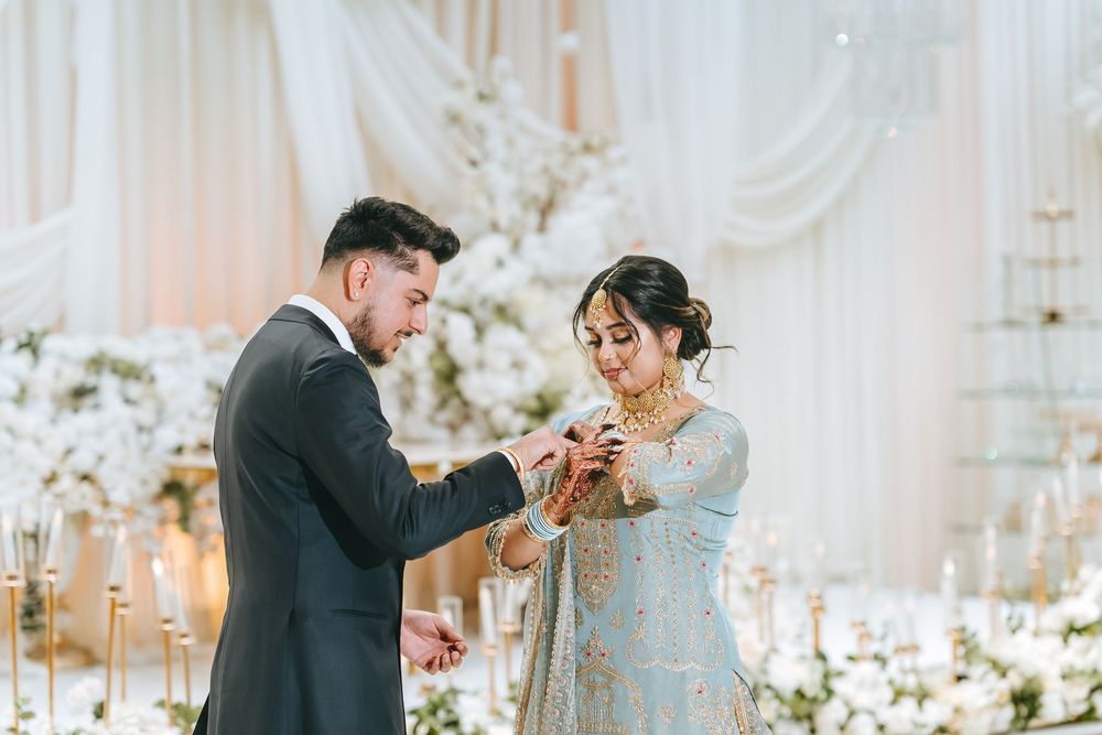 Candid wedding moments captured in a light-filled venue with elegant white drapery and floral arrangements.