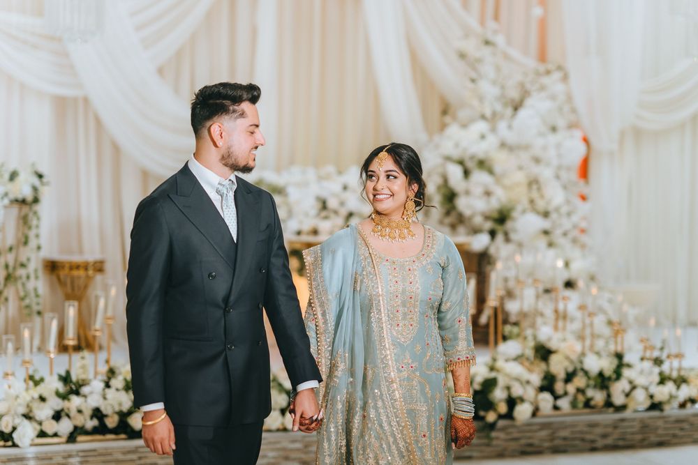A couple shares a romantic moment in a beautifully decorated wedding venue with white drapery.