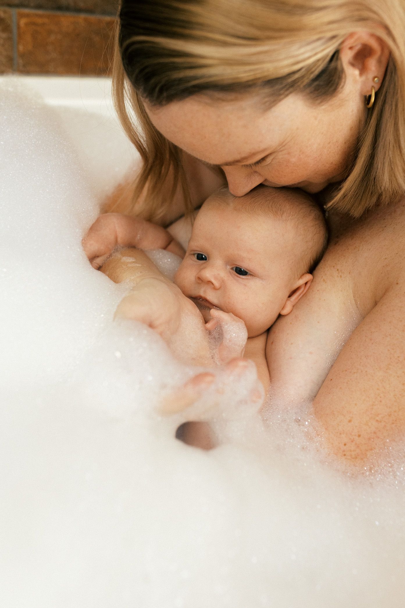 Tender moment between parent and infant captured in soft natural lighting showing gentle nurturing care.