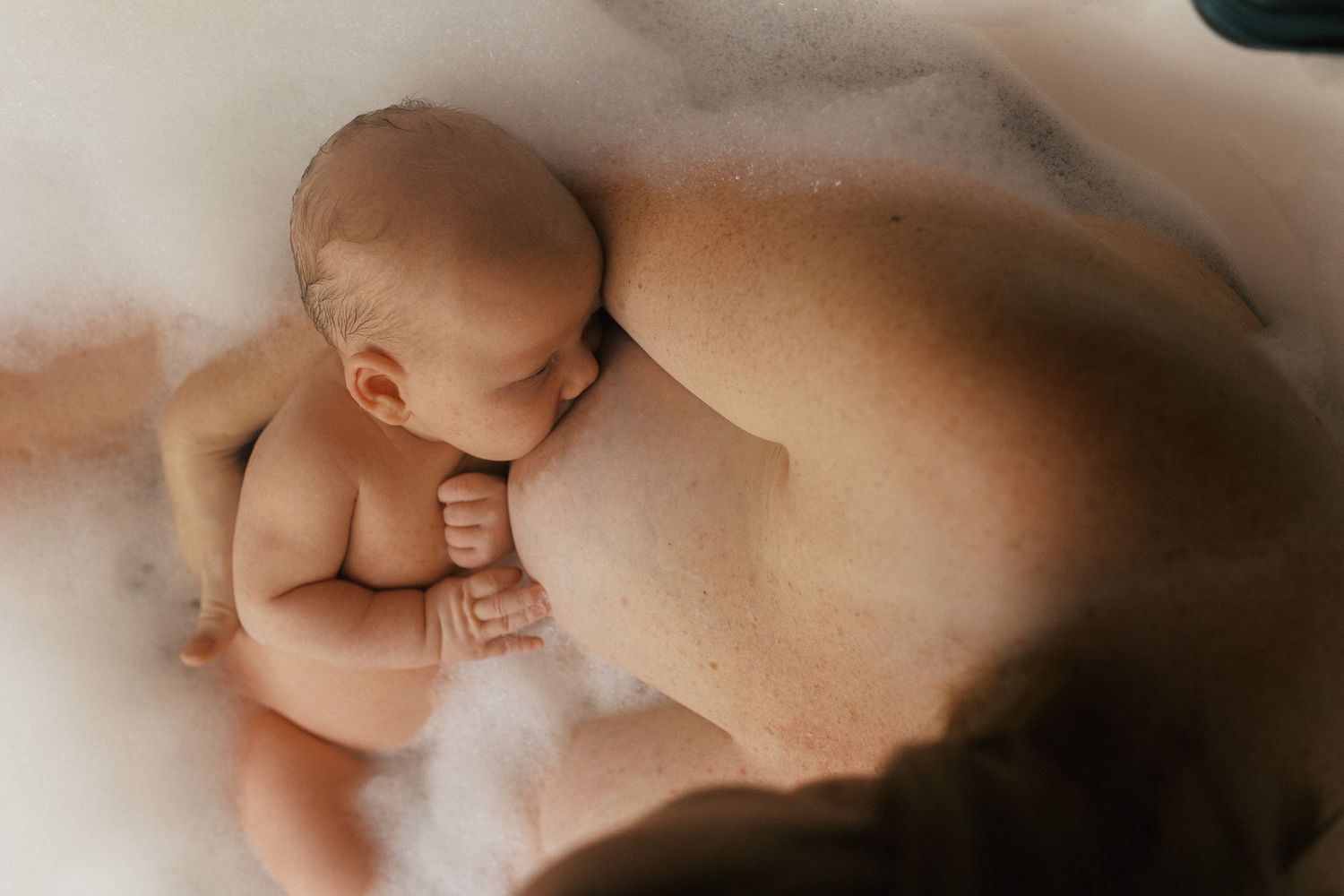 Artistic maternity photo showing gentle curves and shadows in warm lighting.