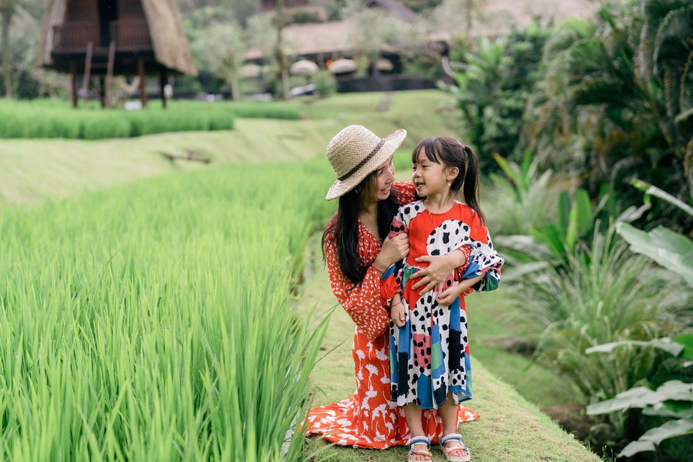 Couple enjoying a romantic walk through lush green rice terraces in Bali.