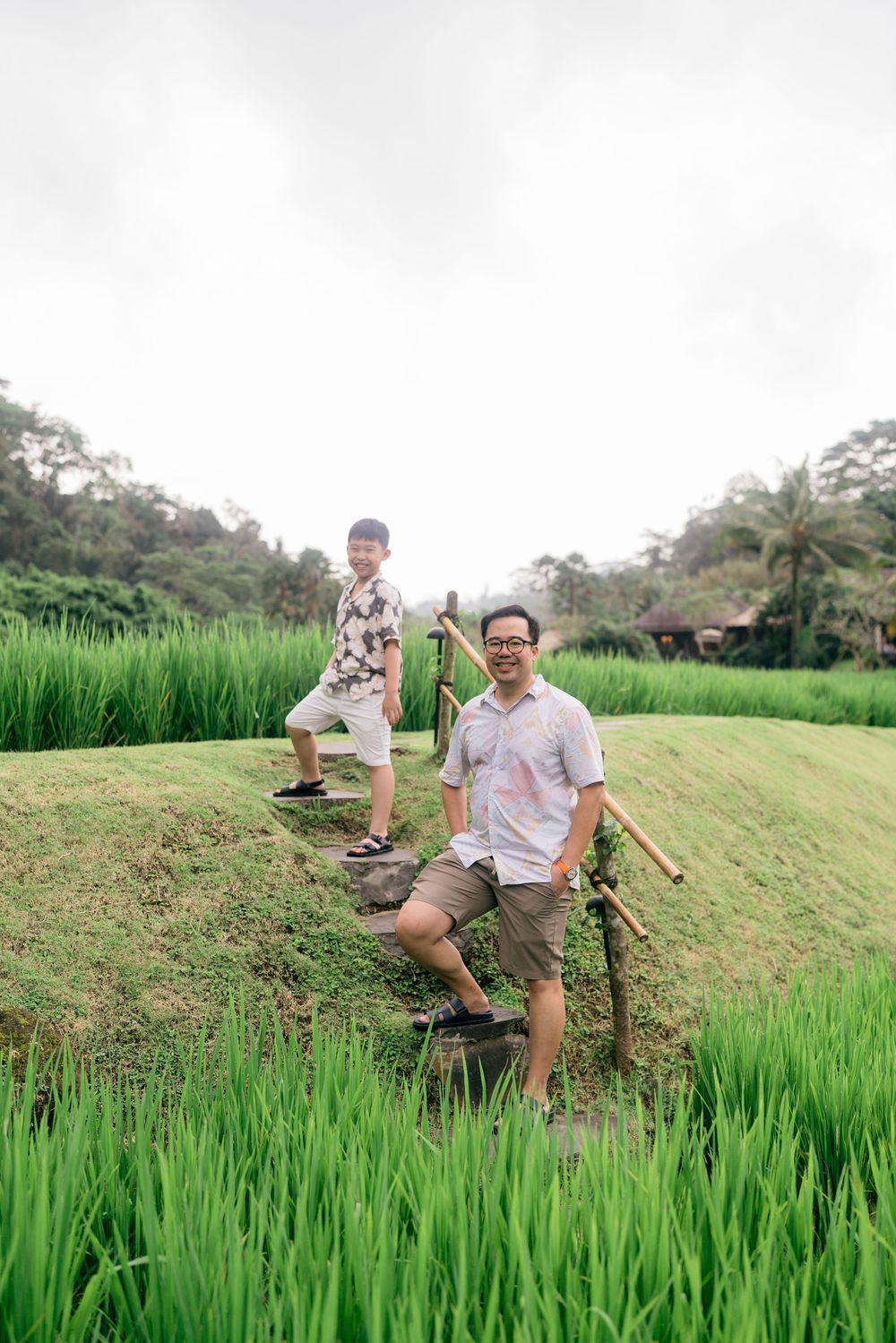 People exploring scenic rice paddies with traditional Balinese architecture in background.