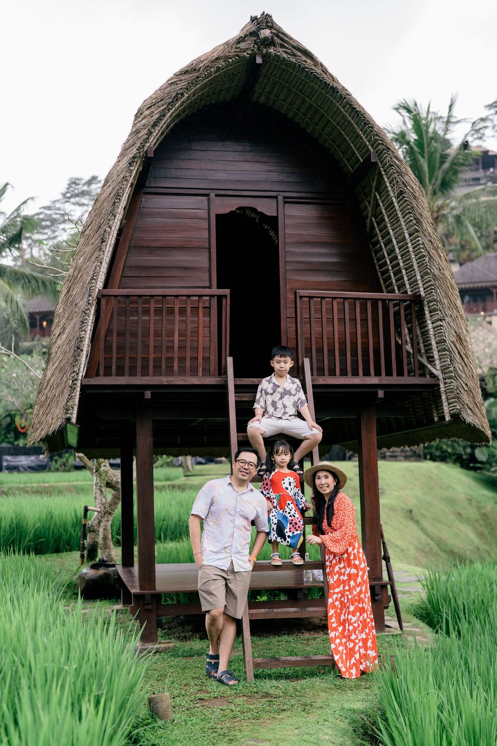 Traditional thatched-roof wooden bungalows nestled among rice terraces in Bali.