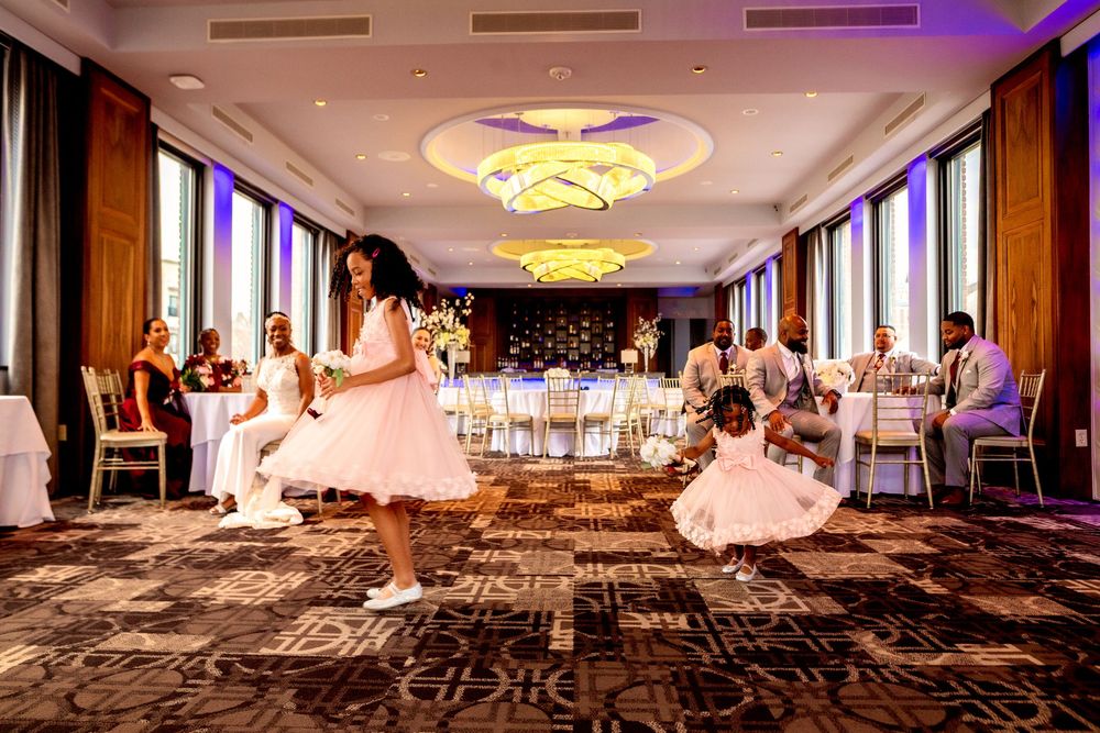 Elegant ballroom with purple lighting, ornate ceiling details, and patterned carpet showcases luxurious event space setup.